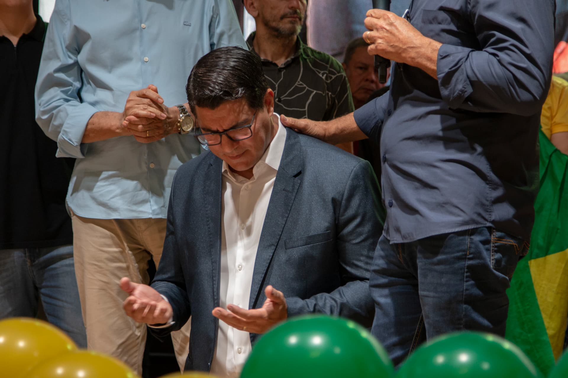 Anderson Lima em momento de oração, cercado por apoiadores